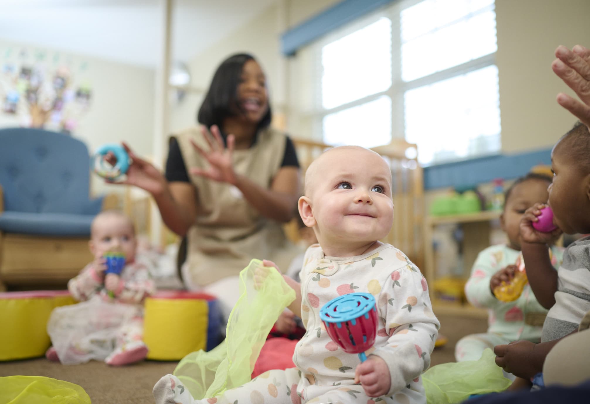 baby smiling while holding a musical instrument