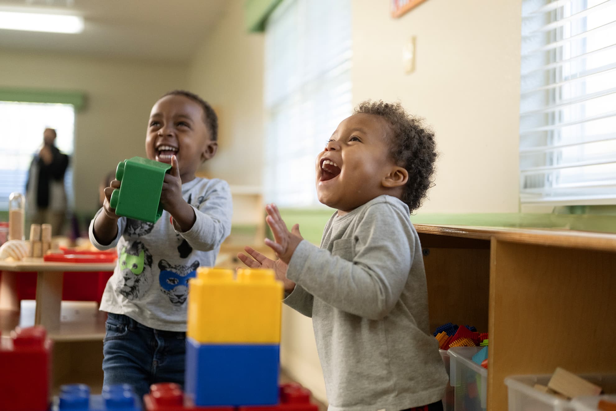 two preschool children smiling and playing together