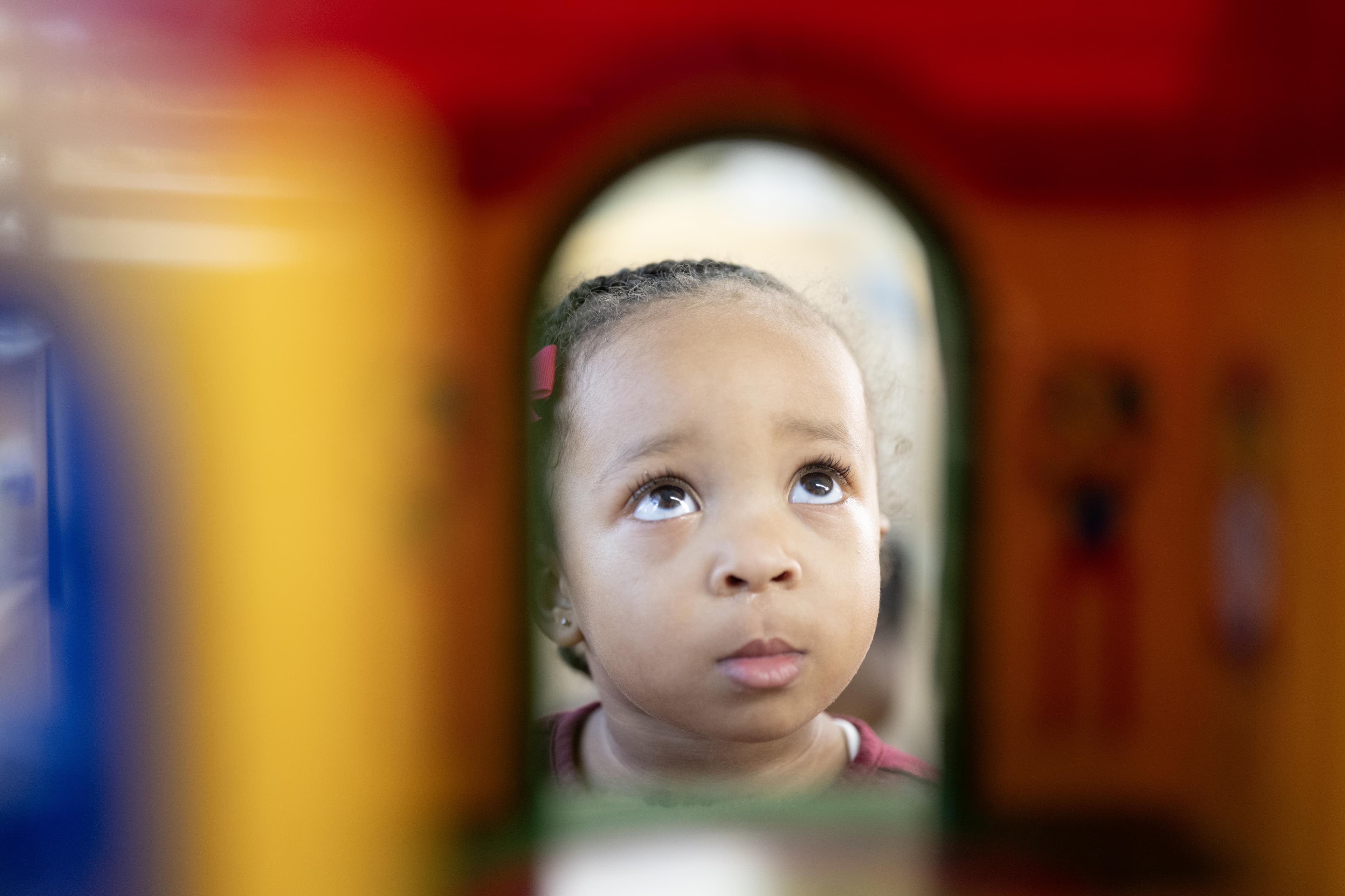 toddler child looking through toys blocks