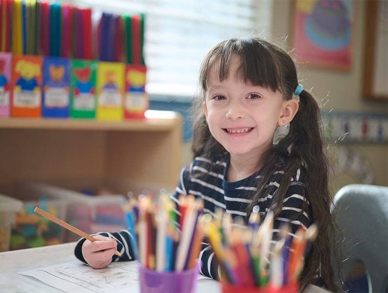 child writing and smiling