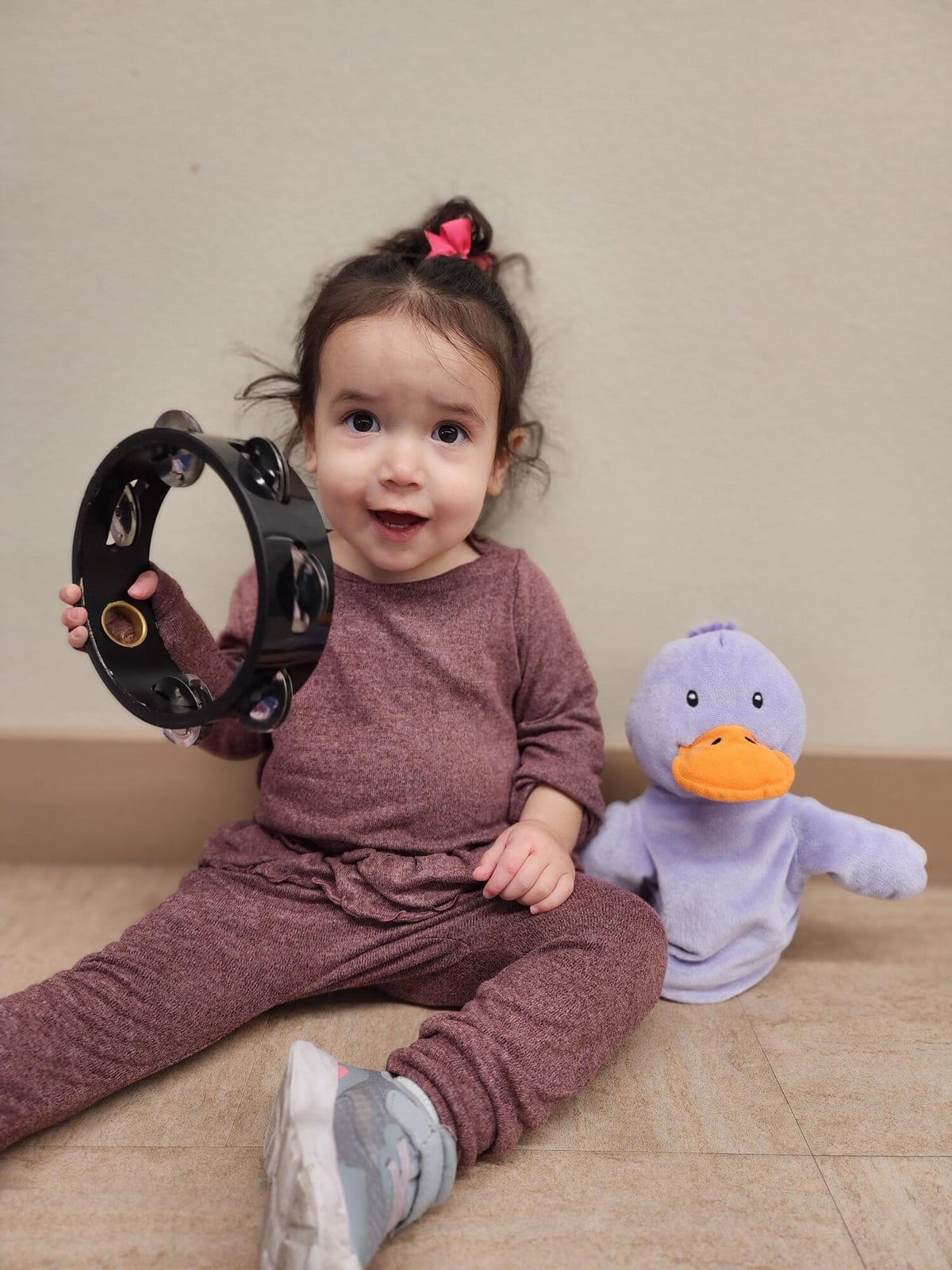 toddler playing a musical instrument during music time Alliance daycare. 