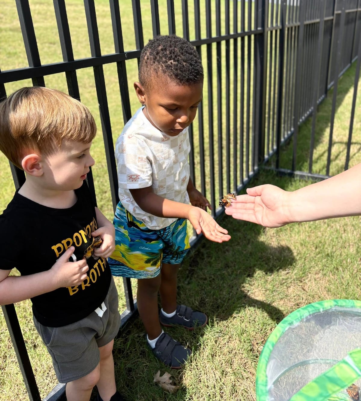 Two preschool kids learning about natural science and butterflies outside at the best private preschool in fort worth, saginaw, eagle ranch texas