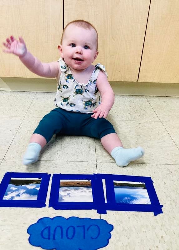 infant baby sitting in front of images of clouds learning about weather and science at Primrose, the best early childcare center near me, fort worth, eagle mountain, texas