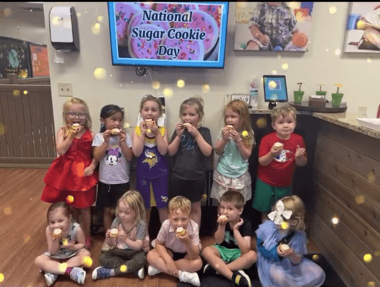 children smiling and eating sugar cookies 