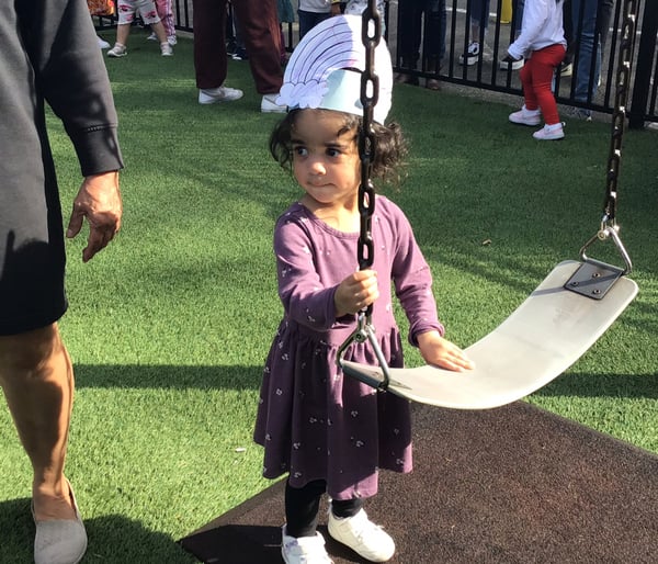 Child with hat for spring hat day parade on playground