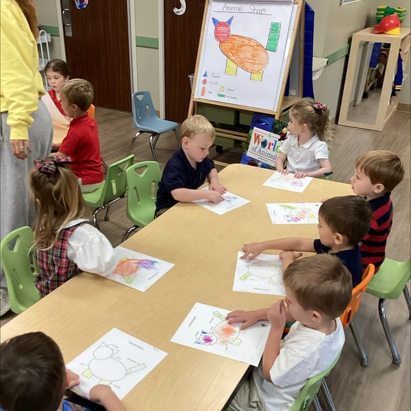 children sitting at table with papers