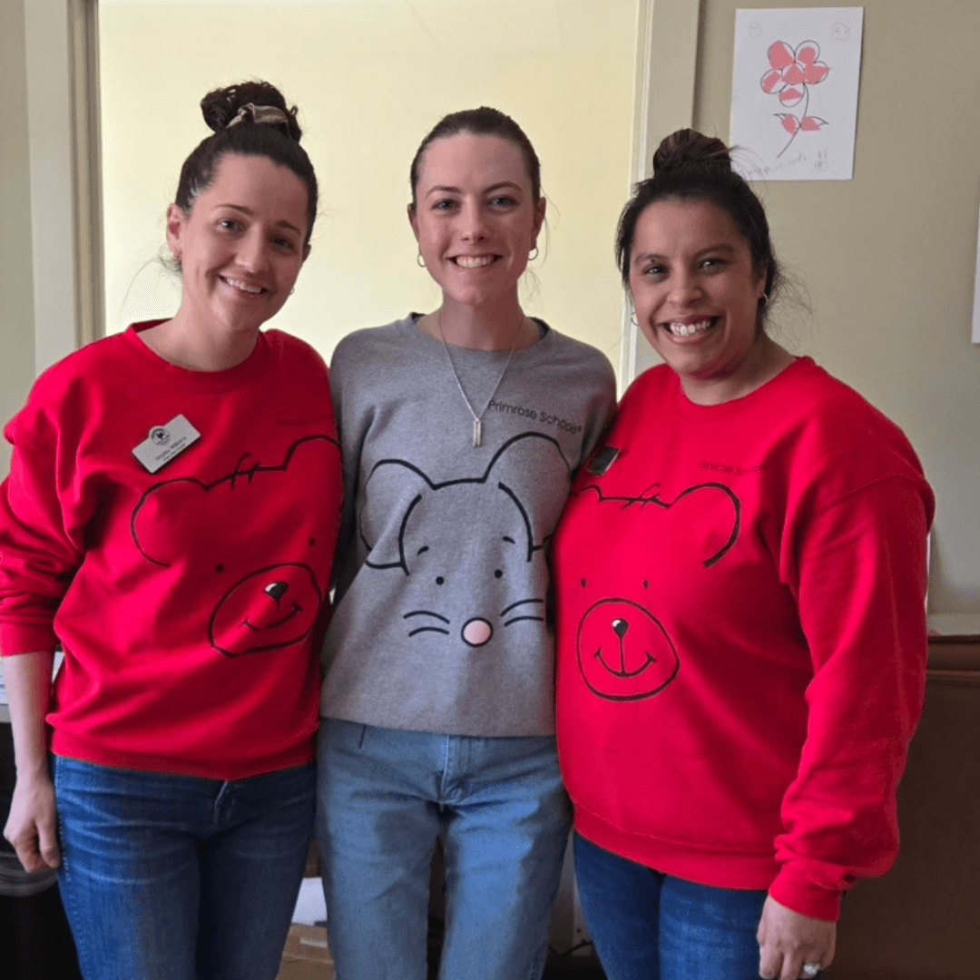 Three women standing in Primrose Friends shirts