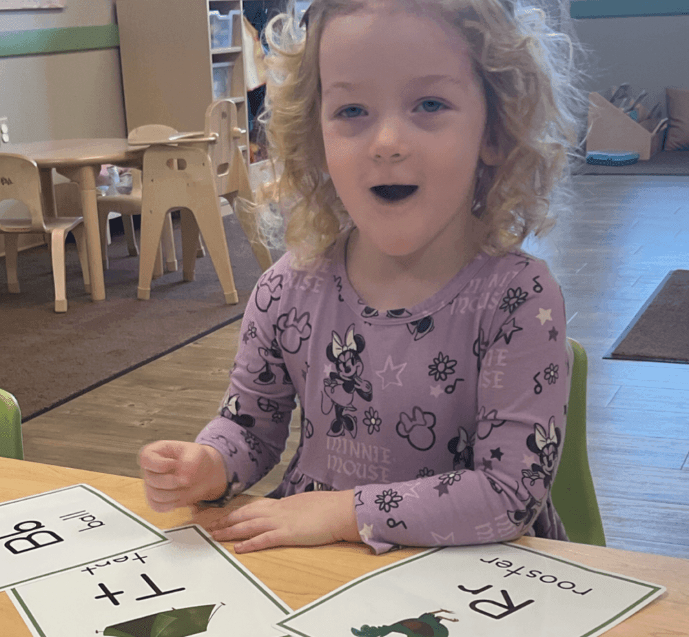 girl sits in purple shirt with mouth open