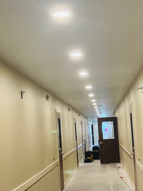 Hallway with brown doors and lights on 