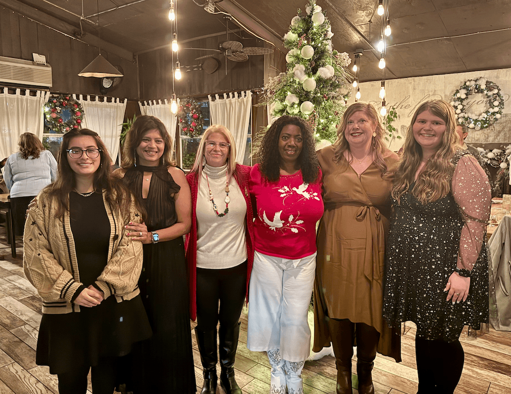 Primrose School of Heritage Wake Forest teachers smiling and celebrating at the staff holiday party.