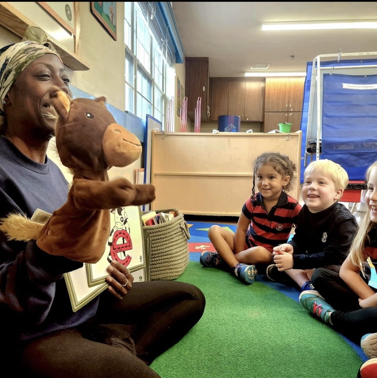 Teacher talking to students using Percy the Pony hand puppet