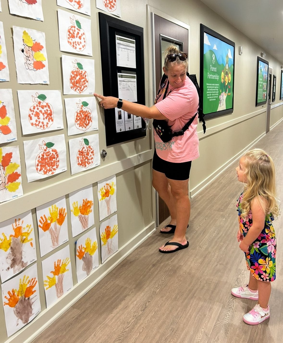 mom and daughter in school hallway looking at artwork