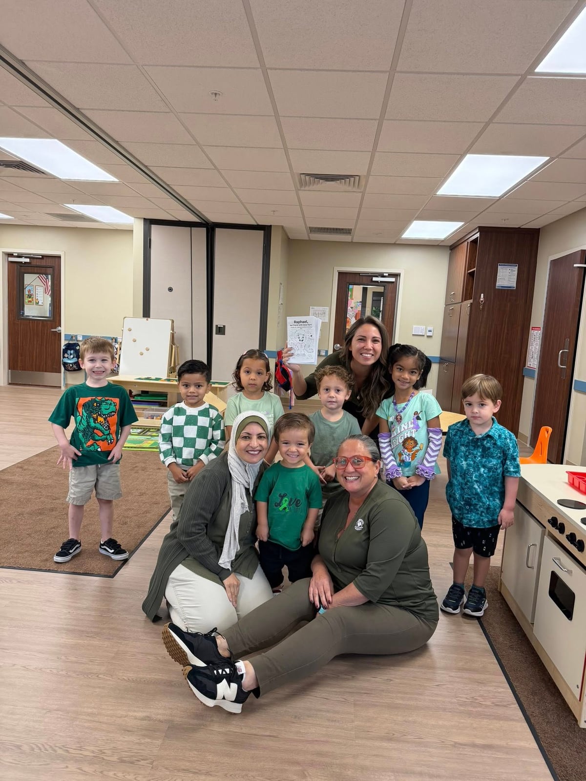 children and teachers dressed in green in a classroom