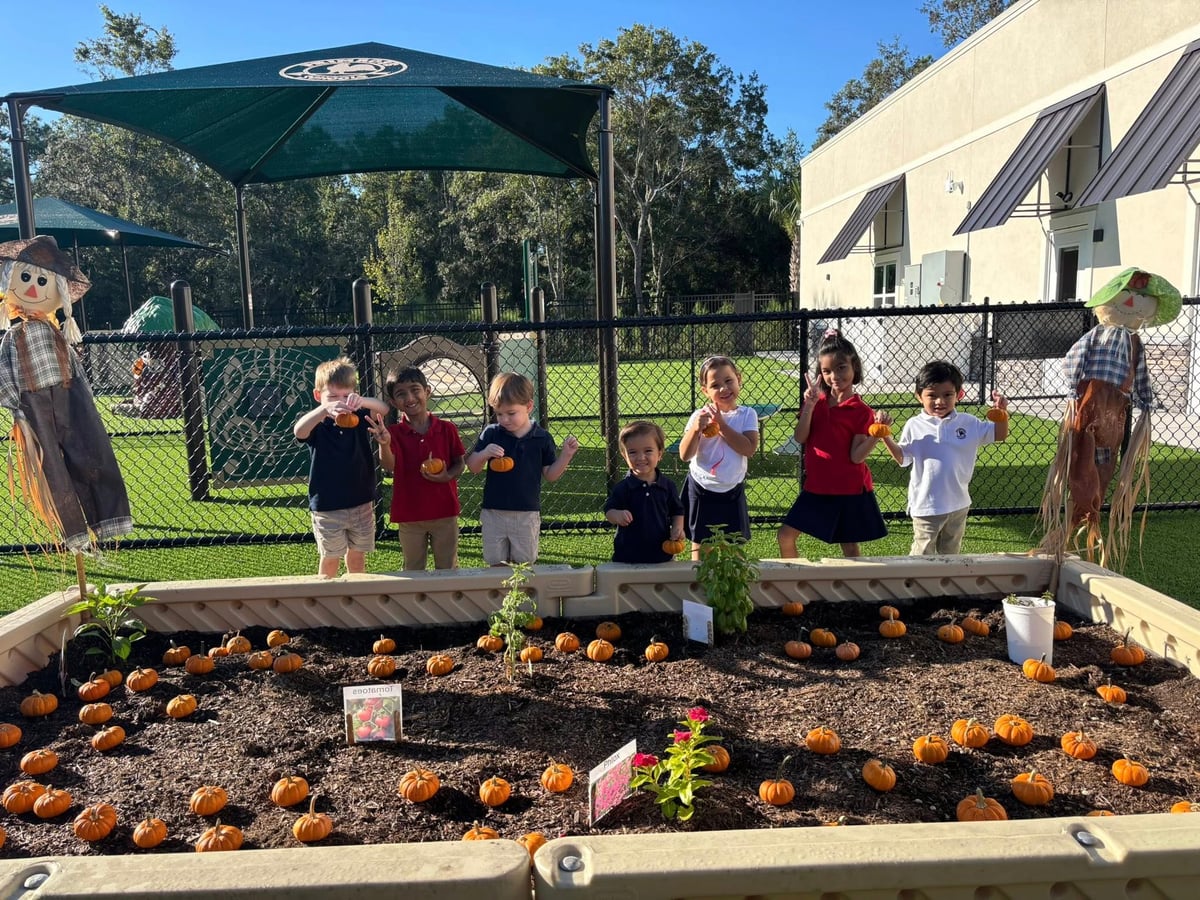 children standing in front of a garden with pumpkins on a playground
