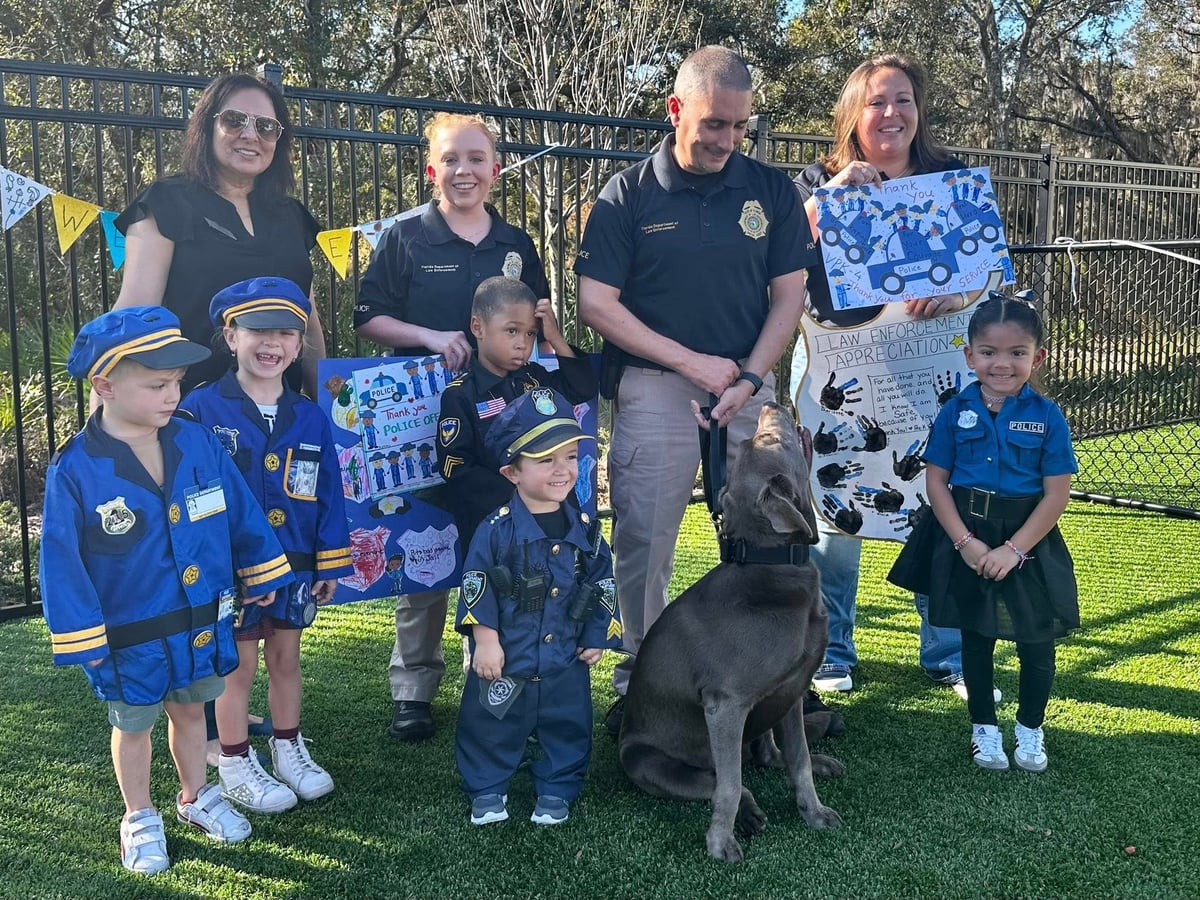 children dressed up as police officers with police officers and a grey dog