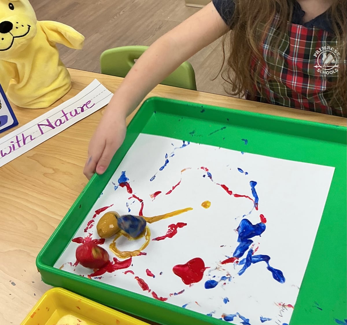 bin with art work being painted with a marble by a child