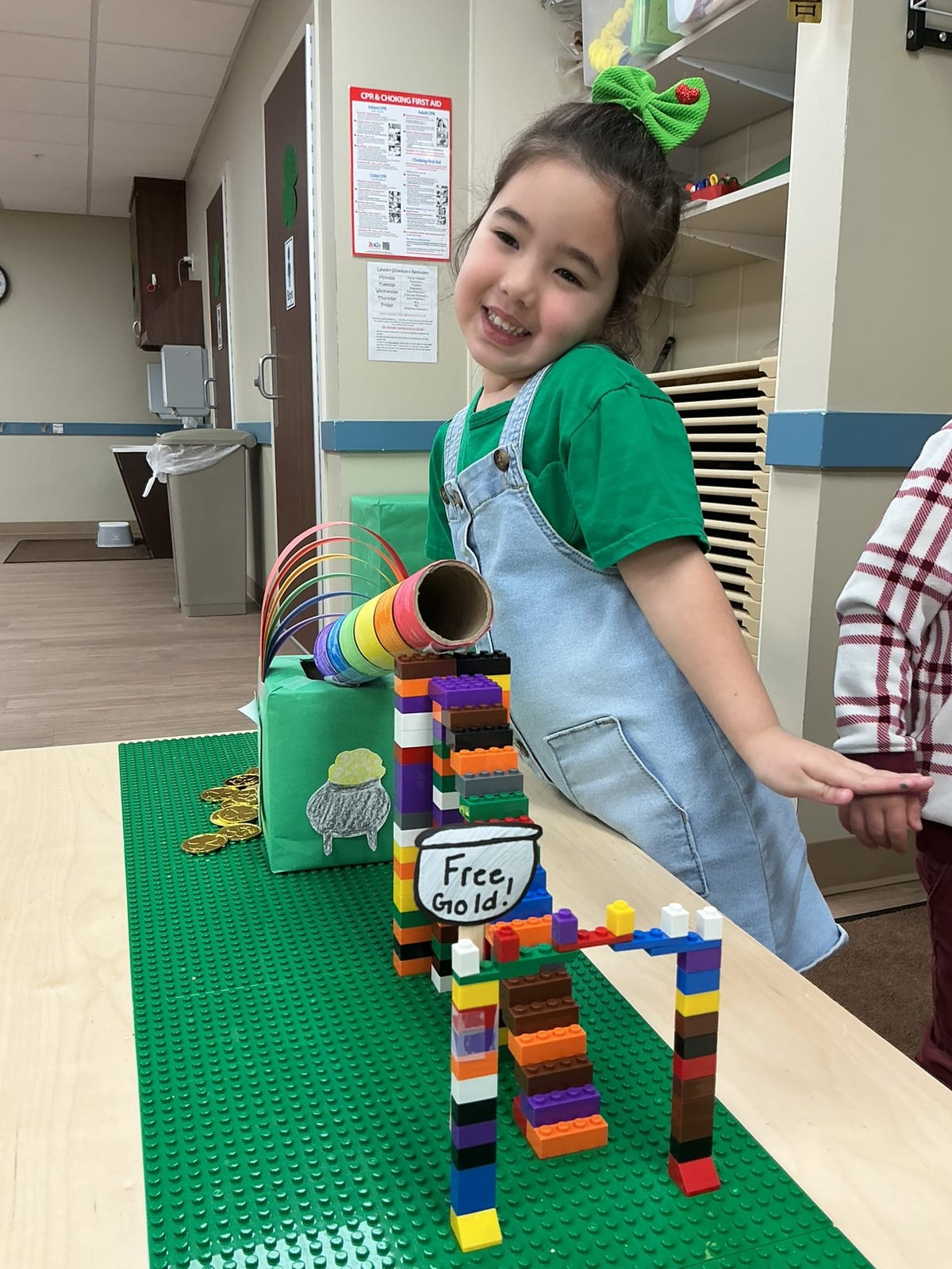 girl in green outfit in front of a leprechaun trap