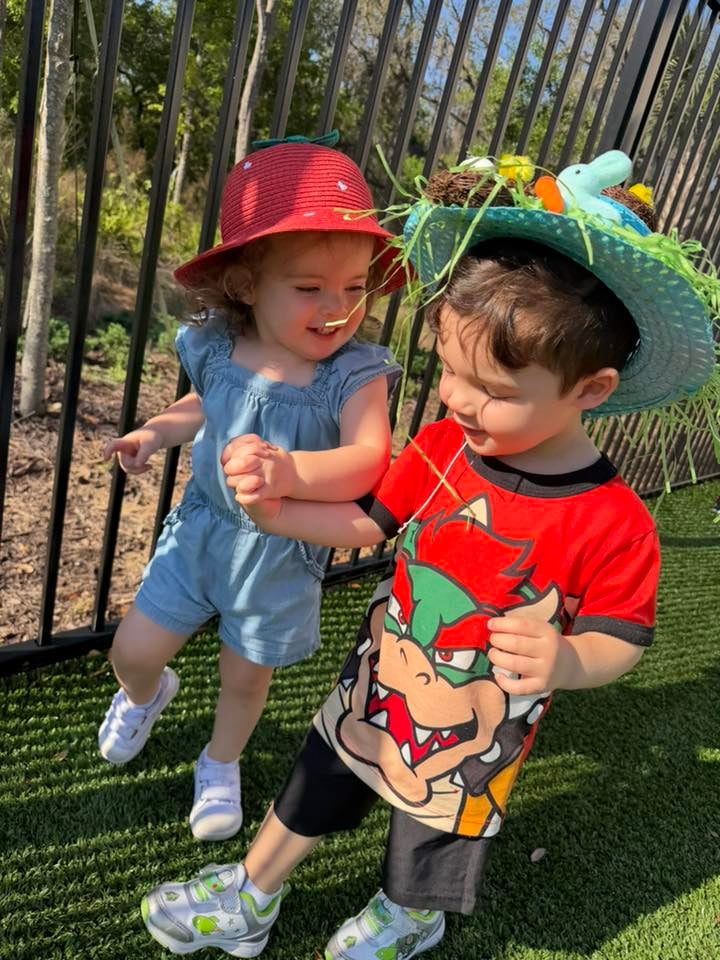 little girl and little boy holding hands wearing spring hats