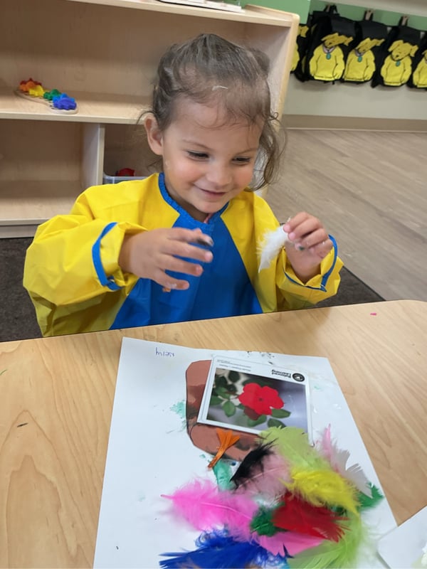 Young girl drawing and creating art in a Primrose preschool classroom during a creative learning activity