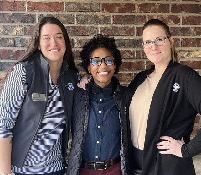 teachers at a group outing holding their artwork and smiling